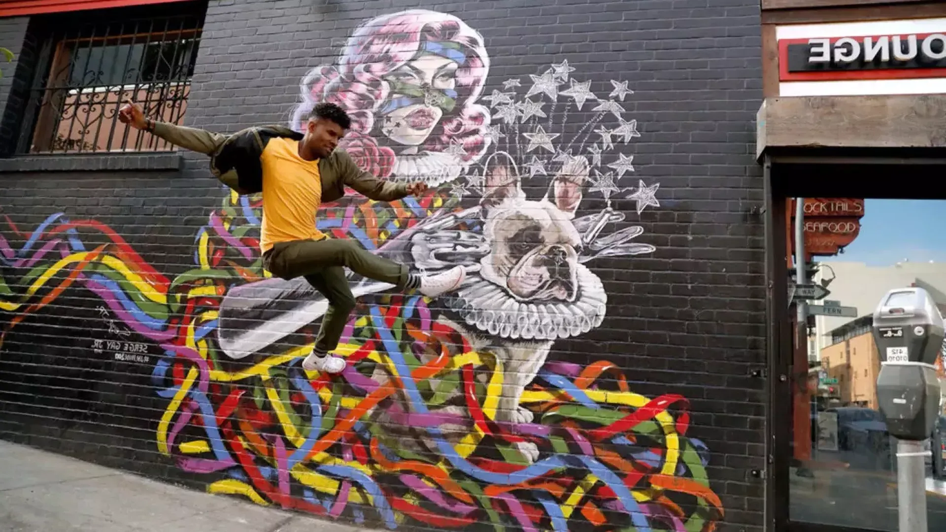 Artist Serge Gay Jr. in front of one of his many murals.